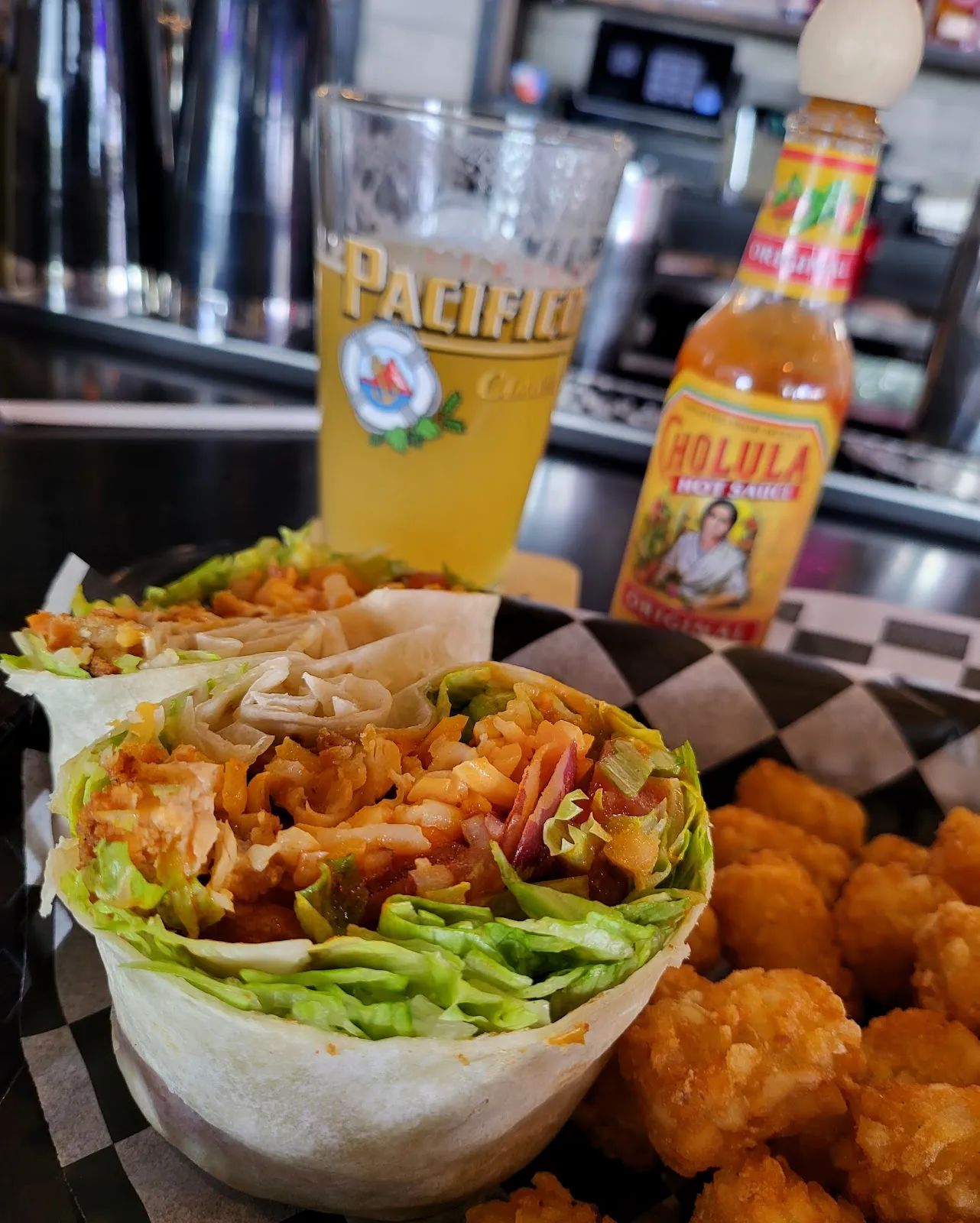 Beer, wrap and tots on the bar